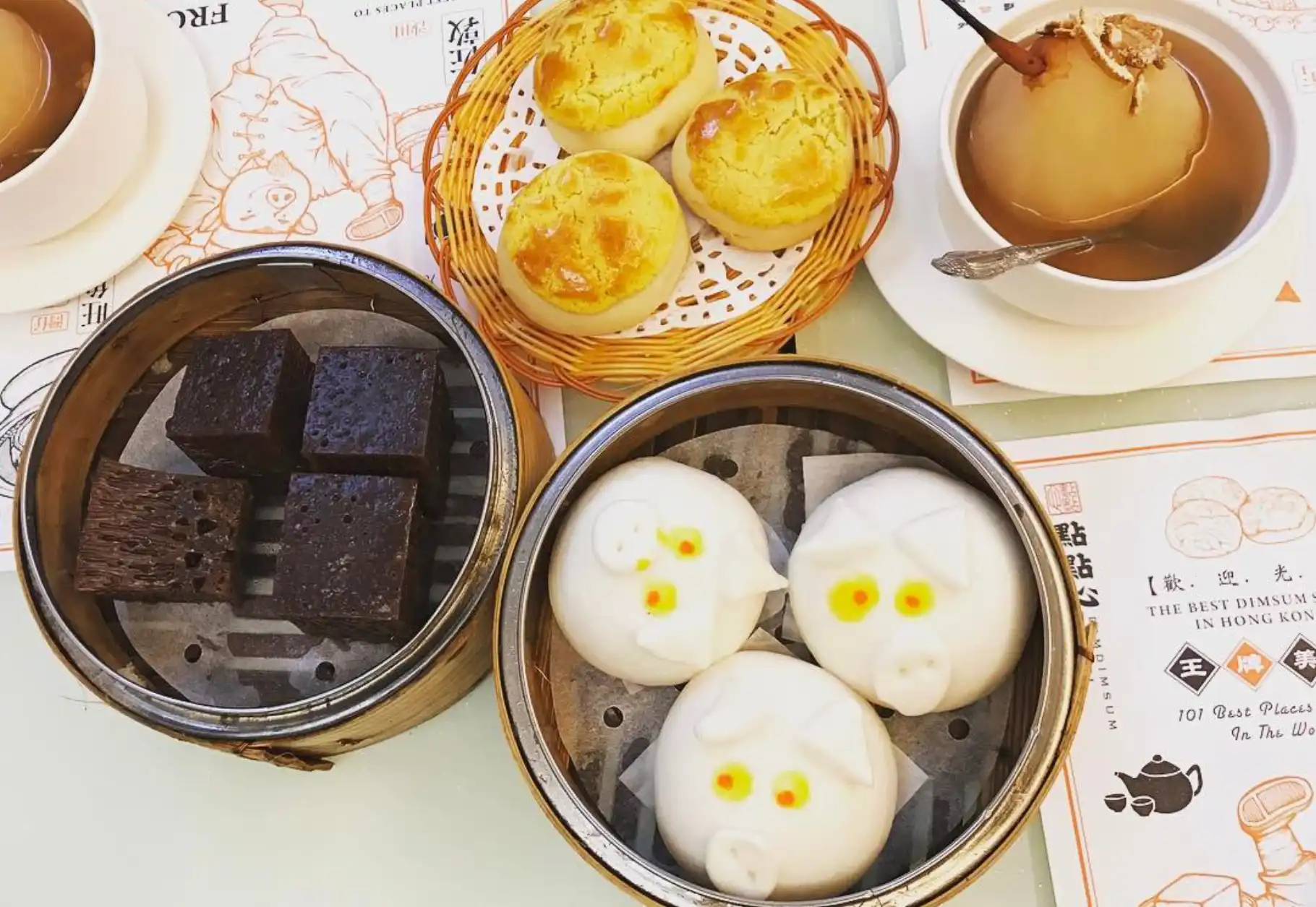 Hong Kong dim sum dishes, pig-shaped steamed buns, Chinese sponge cake squares and pineapple buns